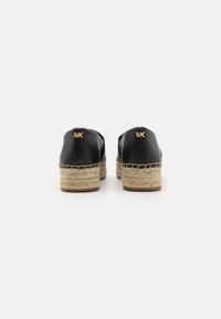 Sorte læderespadriller med en kilehæl indpakket i jute og guld MK-logo detaljer bagpå, med en glat struktur og minimalistisk design.