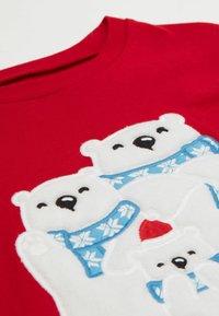 Red sweatshirt featuring embroidered white polar bears with blue scarves and red hat accents, showcasing soft texture and vibrant colors.