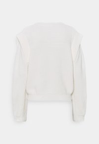 Vit kortärmad tröja med ett strukturerat stickmönster, ribbade ärmar och detaljer vid axlarna. Lätt material, avslappnad design, sömlig rygg.