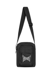 Schwarze Schultertasche mit verstellbarem Tragegurt, rechteckiger Form, aus Stoffmaterial, Frontreißverschlussfach und "TAPOUT"-Logo in Weiß.