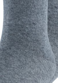 Szare, dziane skarpetki o gładkiej teksturze, z wzmocnioną piętą i palcami. Tkanina ma subtelny melanżowy wzór.