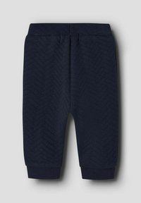 Marineblauwe joggingbroek met een gewaxt visgraatpatroon, elastische tailleband en geribbelde boorden bij de enkels voor een getailleerde look.