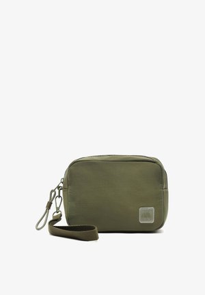 Olive green fabric pouch with a rectangular shape, zip closure, and a small strap. Features a logo patch and smooth, soft texture.