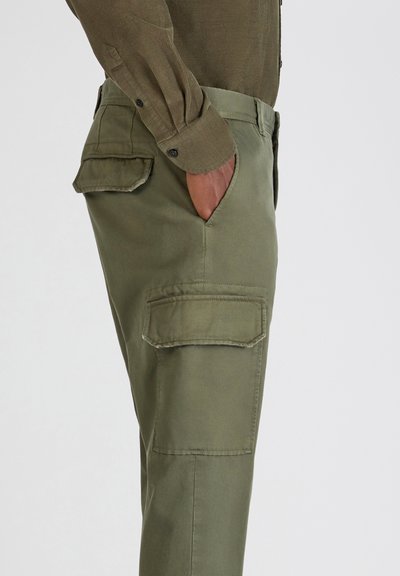 Oliwkowo-zielone spodnie bojówki z wieloma bocznymi kieszeniami i gładką, bawełnopodobną fakturą. Krój prosty, z średnim stanem w pasie.
