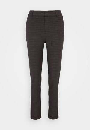 Wąskie spodnie na miarę z małym czarno-brązowym wzorem w kratę i mankietami na nogawkach.