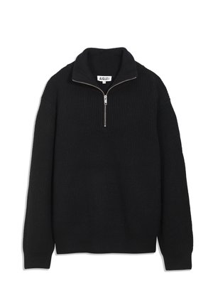 Pull en tricot noir avec un col haut, fermeture éclair mi-longue et poignets côtelés. Le tissu texturé offre une apparence structurée.