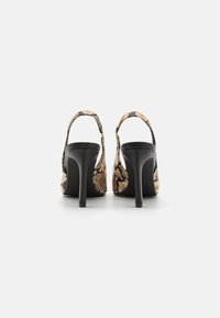 Høyhælte slingback sko med et slangeskinnmønster i beige og svart, med en glatt tekstur og en elegant, buet silhuett.