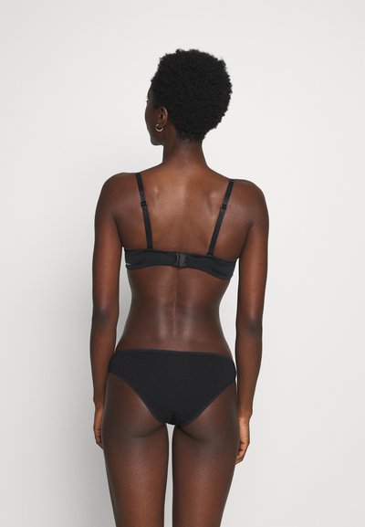 Crni bikini set s jednostavnim dizajnom, podesivim trakama i klasičnim krojem za udobnost. Glatka tekstura s minimalističkim stilom.