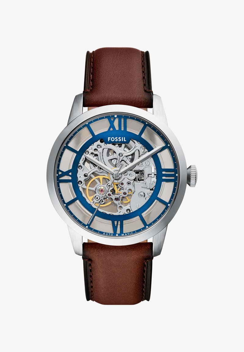Montre automatique avec un boîtier en acier inoxydable argenté, un cadran bleu et argenté, un bracelet en cuir brun et des mouvements mécaniques visibles.