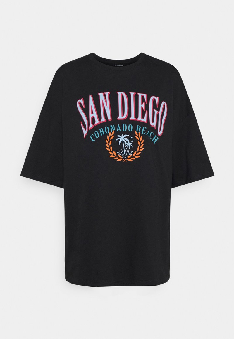 T-shirt oversized noir avec un texte coloré qui dit "SAN DIEGO CORONADO BEACH", agrémenté d'un graphique de palmier et de laurier.