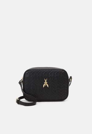 Small black quilted crossbody bag with adjustable strap and a gold metallic insect ornament on front.