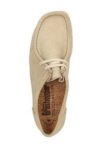 Beige Wildlederschuh mit runder Zehenform, zweilöchrigem Schnürdesign und Korkeinlage mit gedrucktem Branding. Glatte Textur mit Nähdetails.