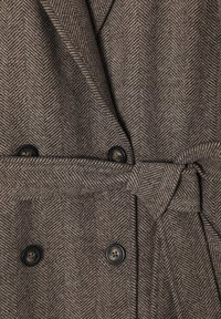 Braun-beige Wellenmuster-Mantel mit doppelter Knopfleiste, schwarzen Knöpfen und einem Stoffgürtel zum Verschließen.
