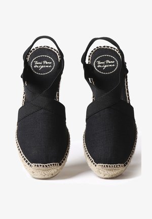 Sandales espadrilles en tissu noir avec semelles en jute tressé et brides croisées, vues de dessus, avec le logo "Toni Pons orígens" à l'intérieur.