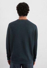 Dunkelgrüner Pullover aus weichem Strickmaterial, mit gerippten Bündchen und Saum, runder Ausschnitt und entspannter Passform.