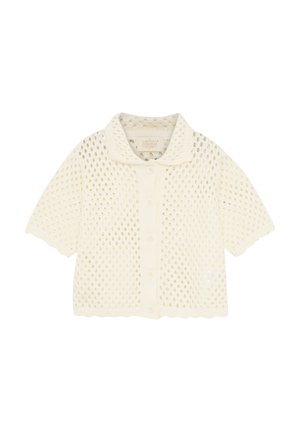 Krótki sweter na krótkie rękawy w kolorze kremowym, wykonany z ażurowego dzianego wzoru, z kołnierzem, zapinany na guziki, z falistymi krawędziami.