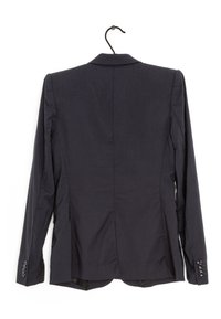 Blazer bleu marine foncé au design structuré, dos à simple boutonnage, revers à pointe et poignets boutonnés. Tissu lisse avec une texture minimale.