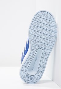 Blå idrottssko sula med ett texturerat mönster av hexagonala former, vita accenter och en präglad logotyp.