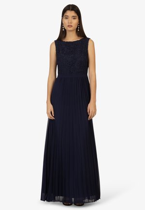 Abito maxi blu navy con design senza maniche, caratterizzato da un corpetto in pizzo floreale e una gonna in chiffon plissettata. Accentuato da una vita liscia.