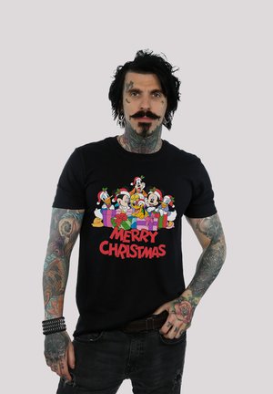 Black cotton t-shirt featuring a colorful Christmas graphic of cartoon characters with presents and the text "Merry Christmas" in red.