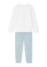 White long-sleeve top with a scalloped neckline and light blue plush pants. The fabric is soft with a smooth texture.
