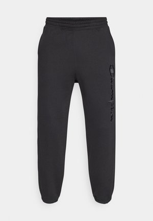 Pantalones deportivos negros con cintura elástica y puños elásticos. Presentan un ligero brillo y un logo texturizado en la pierna izquierda.