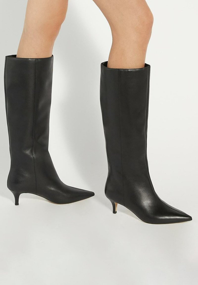 Knee-high black leather boots with a pointed toe and a low cone heel. Smooth texture, minimalist design, sleek silhouette, and no visible hardware.