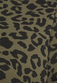 Olive green fabric with a black leopard print pattern. The texture is ribbed, featuring various shapes resembling animal spots.