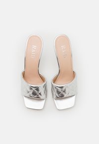 Zilveren slide sandalen met hakken, voorzien van een gequiltte band en een vierkante teen. Zachte binnenvoering, elegante metallic afwerking en minimalistisch ontwerp.