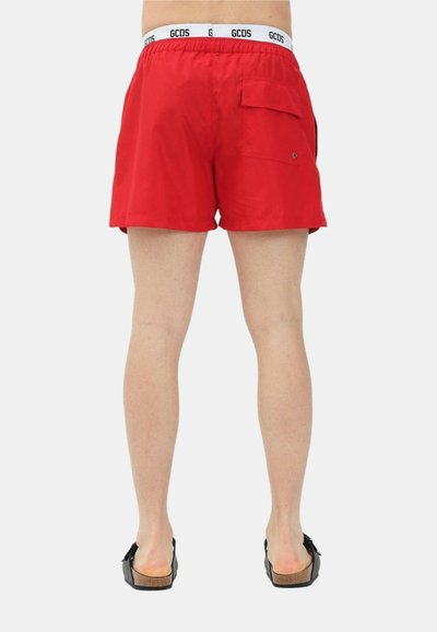 Costume da bagno rosso realizzato in materiale leggero con vita elasticizzata. Presenta una tasca posteriore e un logo del marchio visibile sulla vita.