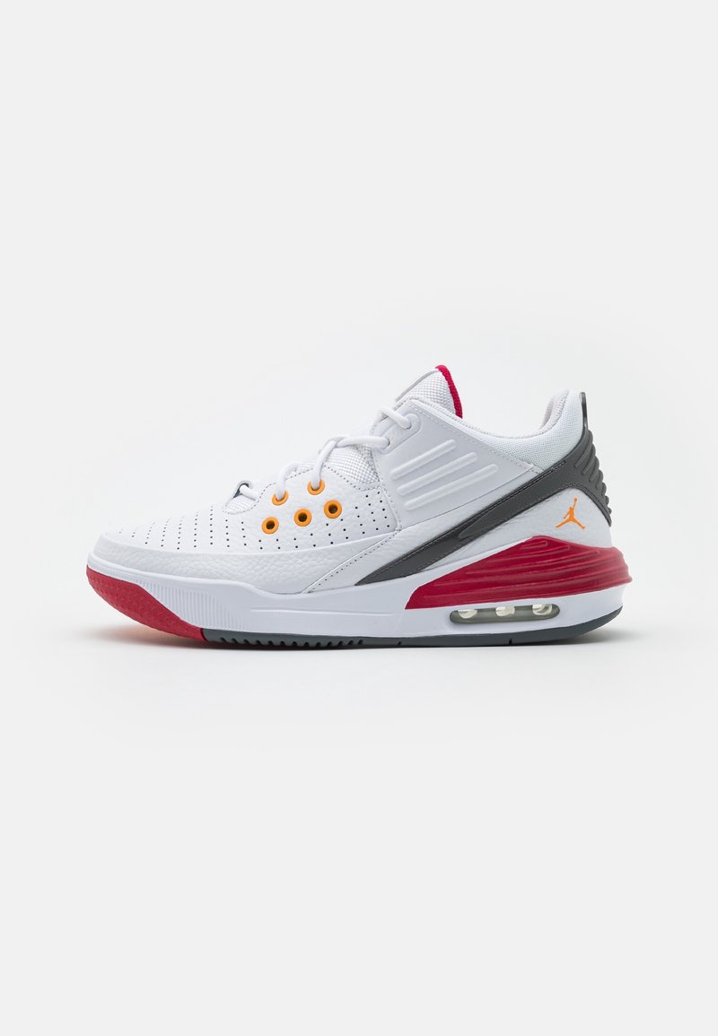 Baskets blanches de sport avec des accents rouges sur la semelle, un maintien de talon noir, des œillets orange et un coussin d’air visible dans la semelle.