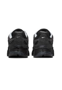 Μαύρα αθλητικά παπούτσια Nike με υφασμάτινο επάνω μέρος, πλέγμα σε πάνελ και διακριτική καμπυλωτή σόλα. Διαθέτουν μικρό λευκό λογότυπο στο πίσω μέρος.