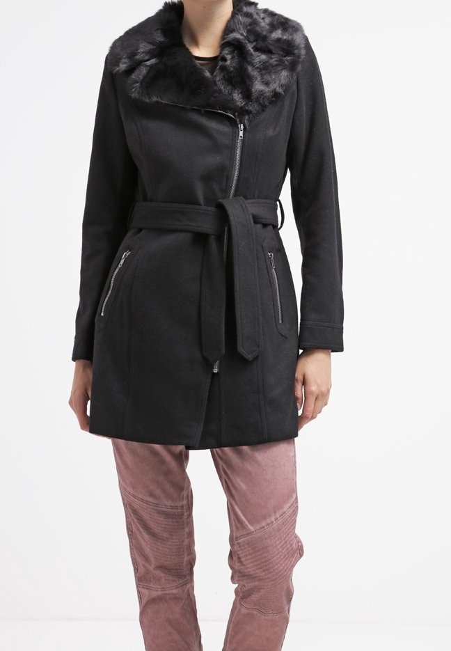 Svart kappa med fuskpälskrage, dragkedja fram och sidofickor. Har ett knytbälte och en texturerad tyg. Kombineras med rosa byxor.