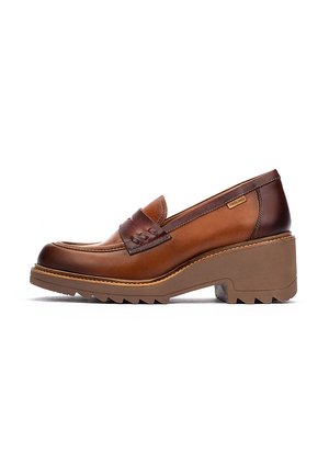 Mocassins en cuir marron avec une pointe arrondie, une courroie décorative et une semelle texturée. Dotées d'un talon épais avec une légère plateforme.