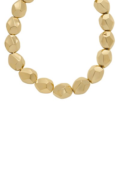 Guldfärgad pärlhalsband med släta, rundade facetterade länkar. Varje länk har en blank yta och oregelbundna geometriska former som skapar en modern design.