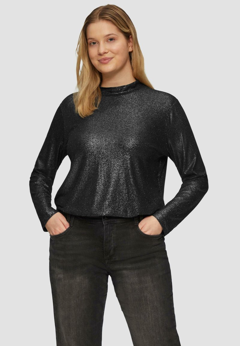 Zwarte langemouwen top met een aansluitend ontwerp, gemaakt van glinsterend materiaal, met een hoge hals en gladde textuur, gecombineerd met donkere jeans.