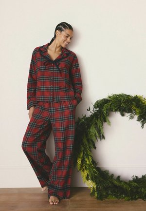 Rød ternet flannel pyjamas sæt med lange ærmer og brede bukser, med krave og knaplukning foran. Kombineret med en grøn foliede accent.