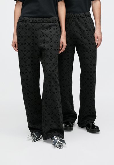 Melni sporta bikses ar rakstainu faktūru, ar brīvu piegriezumu un elastīgu vidukļa jostu. Ievērojams elements ir logotipa dizains visā biksēs.