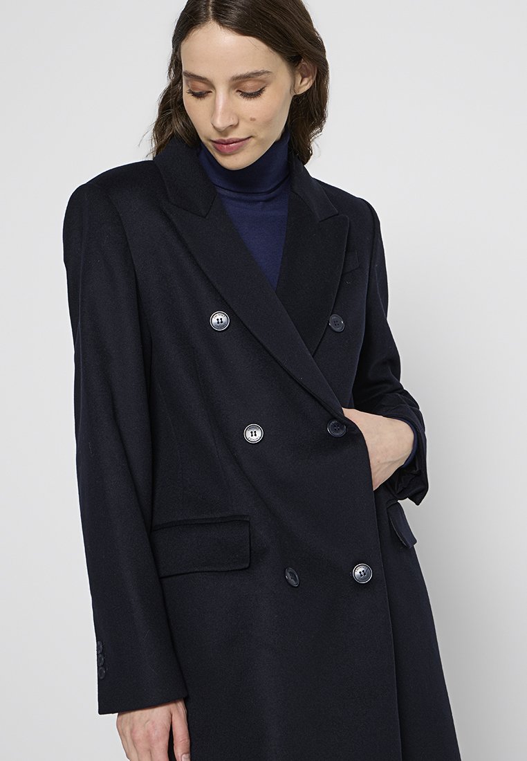 Marineblauwe double-breasted jas van een wolmix met grote knopen, geknipte revers en zakken aan de zijkant, met een getailleerde pasvorm en een gladde textuur.