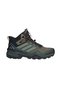 Zapato de senderismo alto en verde y negro con cordones naranjas, suela resistente, etiqueta Gore-Tex y marca Adidas Terrex en el talón.