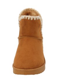 Bottine en daim marron avec une douce doublure en fourrure et des coutures couleur crème le long du bord supérieur. Semelle plate en caoutchouc, design à bout rond.