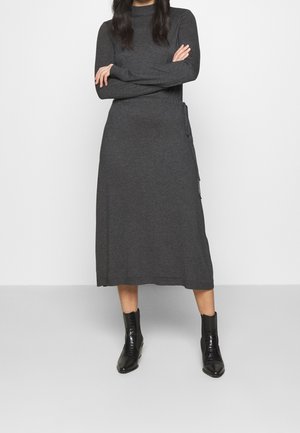 Robe longue grise avec un col montant, des manches longues et des boutons latéraux. Fabriquée en tissu doux, elle présente une coupe décontractée et une silhouette droite.