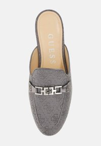 Pantof gri slip-on cu un superior din țesătură texturată, având un accent cu cataramă argintie cu logo și o branț bej cu branding "GUESS".
