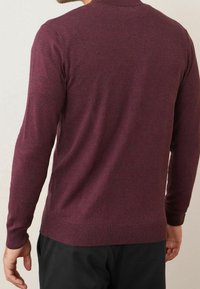 Pull à manches longues bordeaux en maille douce, avec un col et un ourlet côtelés, une texture lisse et une coupe ajustée.