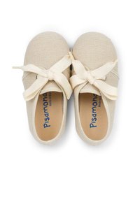 Beige canvas shoes with a woven texture, featuring large cream-colored bows at the front and a natural-colored insole with blue text.