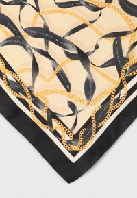 Μεταξωτό φουλάρι με μπεζ φόντο, μαύρες κορδέλες και σχέδια με χρυσή αλυσίδα. Τελειωμένα άκρα σε μαύρο χρώμα, που αναδεικνύουν το σχέδιο.