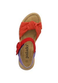 Sandalia multicolor con una banda de tejido retorcido roja y acentos morados. Material de gamuza suave con una plantilla acolchada beige y forma redondeada.