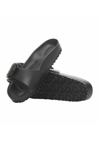 Sandali in silicone neri con una suola interna testurizzata e una fascia ampia che presenta una fibbia decorativa. La suola esterna ha un battistrada stampato per garantire aderenza.