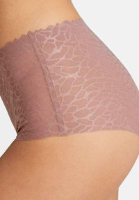 Hoogwaardige, lichtroze kanten slip met gegolfde randen en een bloemenpatroon, gemaakt van een doorzichtige, gestructureerde stof.
