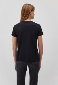 Schwarzes Kurzarm-T-Shirt aus weicher Baumwolle mit Rundhalsausschnitt. Leicht lockere Passform, minimalistisches Design und saubere Saumdetails.